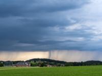 Dunkle Regenwolken über Aschau-Höhenberg die sich in Schleier ergießen